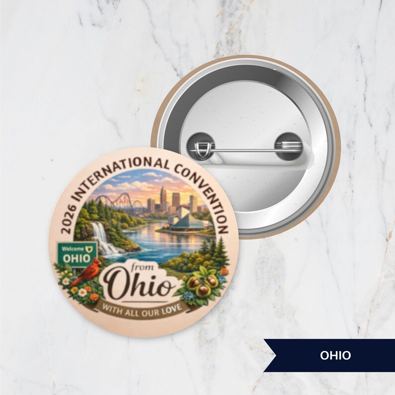 May include: A round pinback button featuring a colorful illustration of an Ohio landscape with a city skyline, a waterfall, a cardinal, and the text 2026 INTERNATIONAL CONVENTION from Ohio WITH ALL OUR LOVE. The back shows a metal pin mechanism.