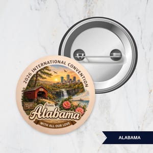 May include: A round pinback button featuring a scenic illustration of a covered bridge, a waterfall, and a city skyline. The text reads 2026 INTERNATIONAL CONVENTION from Alabama WITH ALL OUR LOVE. The back shows a metal pin mechanism.