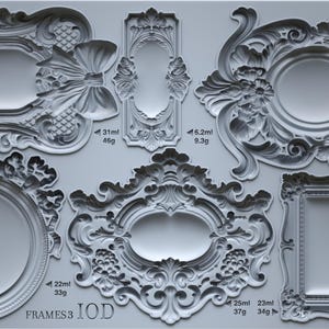 May include: A gray silicone mold featuring various ornate frame designs. The frames include oval, rectangular, and bow-shaped elements, with detailed scrollwork and floral accents. The mold is labeled "FRAMES3 IOD".