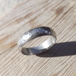 May include: A silver hammered band ring with a smooth inner surface.