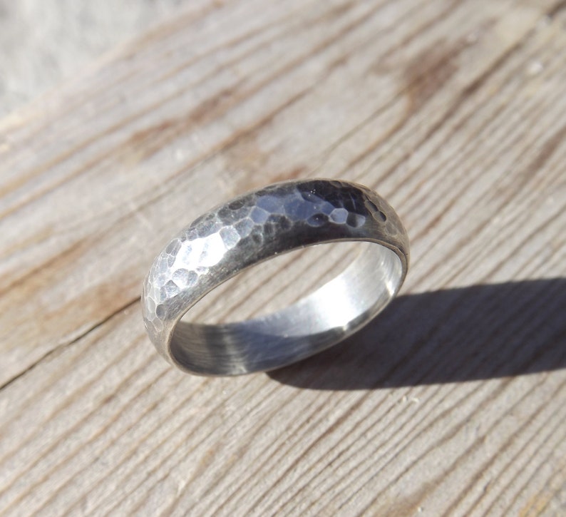 May include: A silver hammered band ring with a smooth inner surface.