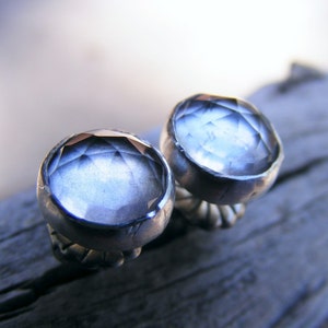 May include: A pair of silver earrings with faceted clear quartz stones.