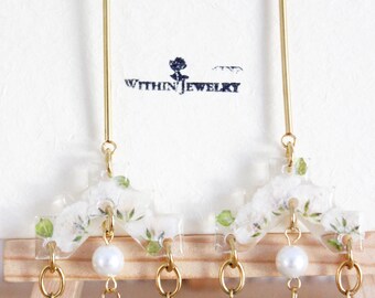 May include: Gold-toned earrings with a floral design and various gemstone and pearl accents. The earrings feature a long, thin gold post, a floral-shaped top, and dangling elements with stacked stones in shades of blue, green, and red. The brand name "WITHIN JEWELRY" is visible.
