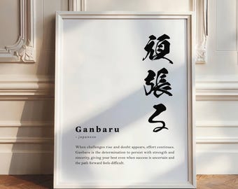 May include: A framed white print with Japanese calligraphy and the word "Ganbaru" in English. The print includes a definition of "Ganbaru" which means to persist with strength and sincerity.