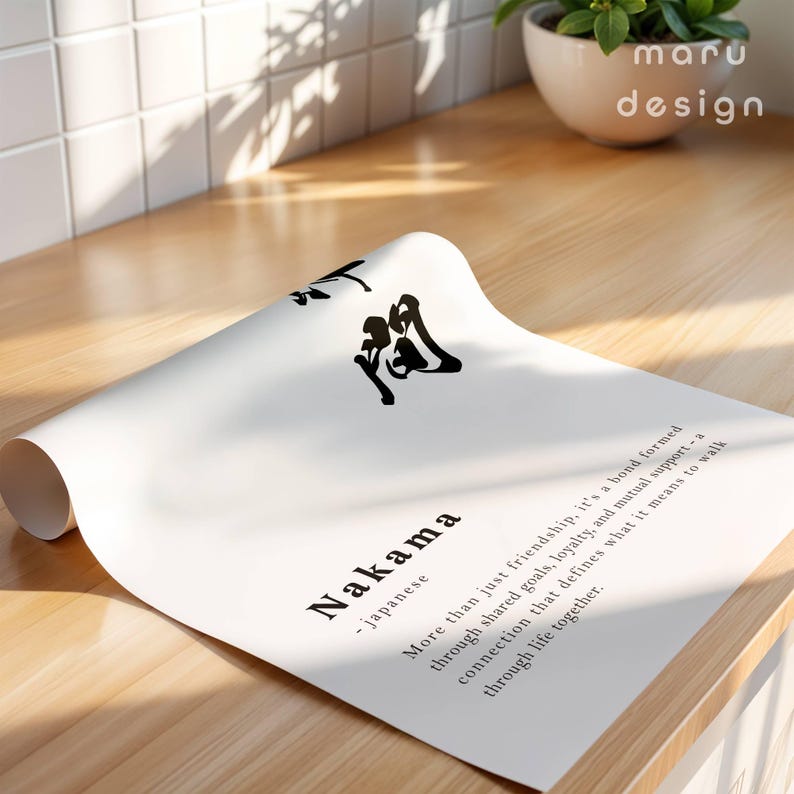 May include: A white poster with black Japanese calligraphy and the English text Nakama, defined as a bond formed through shared goals, loyalty, and mutual support, a connection that defines what it means to walk through life together.