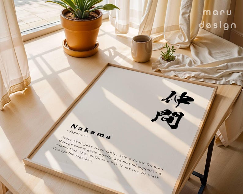 May include: A framed wall art print featuring the Japanese word Nakama in black calligraphy, followed by the English definition: More than just friendship, it's a bond formed through shared goals, loyalty, and mutual support.