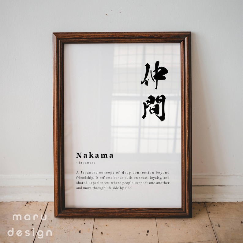 May include: A framed wall art print featuring the Japanese kanji for Nakama in black ink. Below the characters, the word Nakama is printed in bold, followed by the definition of the Japanese concept of deep connection and friendship.