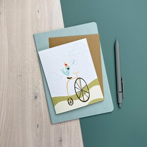 Cartão ilustrado de aniversário de pássaro festeiro em bicicleta (único)