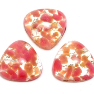 May include: Three pink and silver iridescent glass cabochons in a triangle shape.