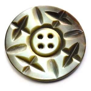 May include: A four-hole, iridescent, mother-of-pearl button with a carved floral design.