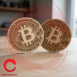 May include: Two wooden Bitcoin coins with intricate engraved designs. The coins feature the Bitcoin symbol and text around the edges, including "DIGITAL-DEGENTARLIZED-PEER TO PEER" and "1AV OZ, 999 FINE COPPER M". The coins are displayed on a light-colored surface.