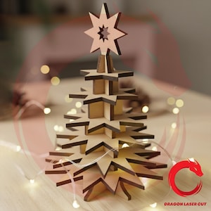 May include: A wooden Christmas tree with a star topper. The tree is constructed from layered star-shaped pieces, creating a three-dimensional effect. The tree is made of light-colored wood with darker edges. A string of lights is wrapped around the tree.
