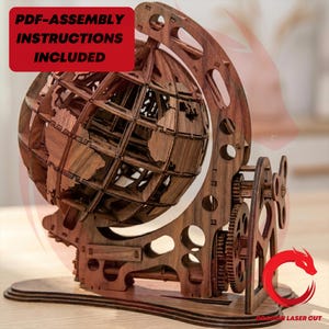 Könnte beinhalten: Ein Holzglobus-Modell mit aufwendigen Laser-Cut-Details, das eine kugelförmige Weltkarte zeigt. Das Modell enthält Zahnräder und einen Ständer, mit dem Text "PDF-ASSEMBLY INSTRUCTIONS INCLUDED" auf rotem Hintergrund. Der Globus ist aus Holz.