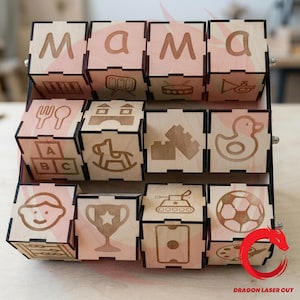 May include: A wooden display rack holding twelve square blocks arranged in three rows. The top row spells out the word mama. Each block features laser-engraved icons including a xylophone, drum, trumpet, fork, spoon, blocks, rocking horse, duck, trophy, tank, and soccer ball.