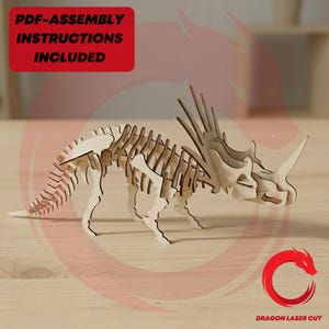 Puede incluir: Rompecabezas de dinosaurio Triceratops de madera con diseño de esqueleto. El modelo es de madera clara y presenta un cuerno largo y un volante. La imagen incluye el texto "PDF-ASSEMBLY INSTRUCTIONS INCLUDED" en un cuadro rojo.