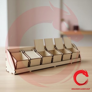 Puede incluir: Un organizador de madera con cinco compartimentos, cada uno con una tapa con bisagras. El organizador está hecho de madera de color claro y tiene forma rectangular. El diseño incluye un panel lateral curvo decorativo. El texto "DRAGON LASER CUT" es visible.