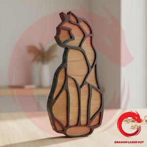 May include: A decorative wooden cat sculpture featuring a segmented design with natural light brown wood grain panels framed by dark brown outlines. The piece displays a stylized feline silhouette and includes the text Dragon Laser Cut.