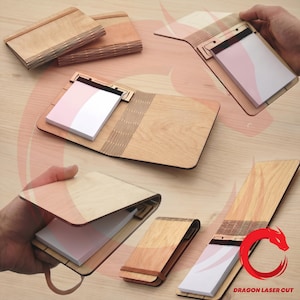 Peut inclure: Plusieurs blocs-notes en bois avec un design découpé au laser. Les blocs-notes sont en bois clair et comportent un bloc-notes avec des pages roses et blanches. Certains sont ouverts, d'autres fermés.