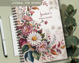 May include: A personalized prayer journal with a floral design. The cover features a large bouquet of pink and white daisies, with accents of red and green leaves. The journal is spiral-bound and includes the text "Personalized Prayer Journal for Women" and "Jessica's Prayer Journal."