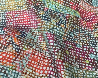 May include: Close-up of a colorful fabric with a dotted pattern. The fabric features a mix of colors, including red, orange, blue, and brown. The design is made up of small dots and lines, creating a textured appearance. The fabric is likely used for clothing or home decor.