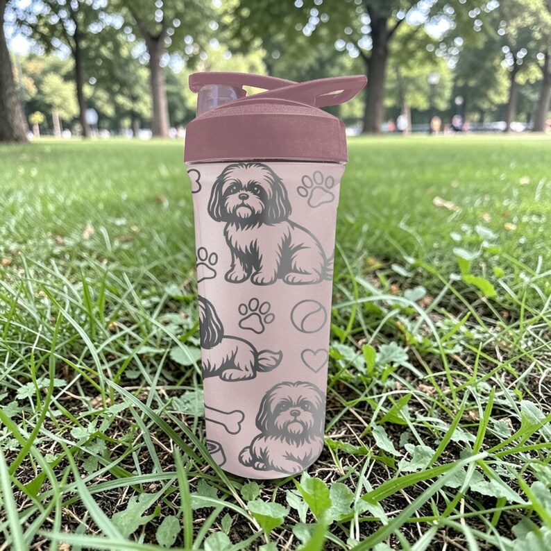 May include: A pink water bottle with a dark pink lid and a flip-top closure. The bottle is decorated with a repeating pattern of Shih Tzu dog illustrations, paw prints, and bones. The bottle is made of plastic and is designed for cold beverages.