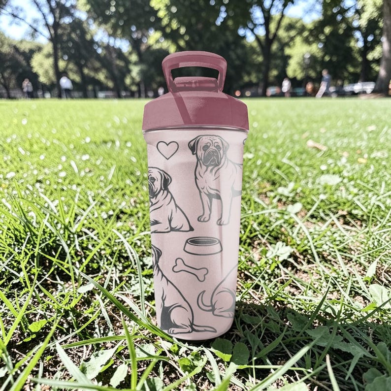 May include: A pink water bottle with a matching lid and handle. The bottle features line drawings of a pug, a dog bowl, a bone, and a heart. The bottle is sitting on green grass.