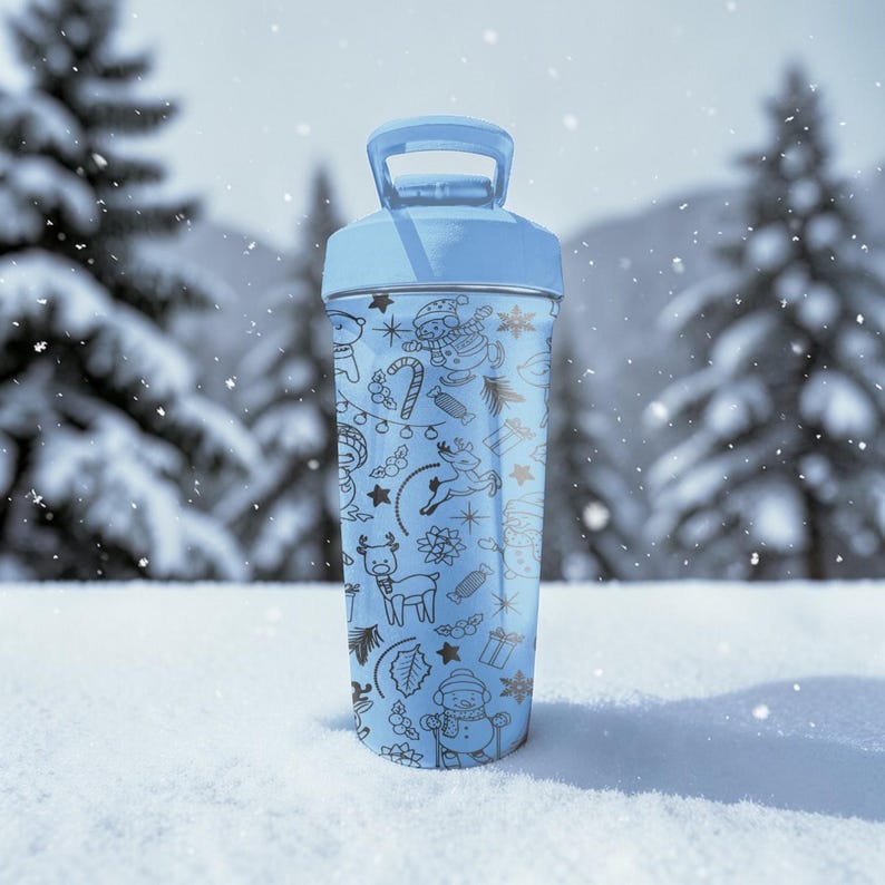 Puede incluir: Una botella de agua azul claro con asa y dise&ntilde;o festivo de invierno. La botella presenta ilustraciones en negro de mu&ntilde;ecos de nieve, renos y bastones de caramelo. El fondo muestra un paisaje nevado con &aacute;rboles.