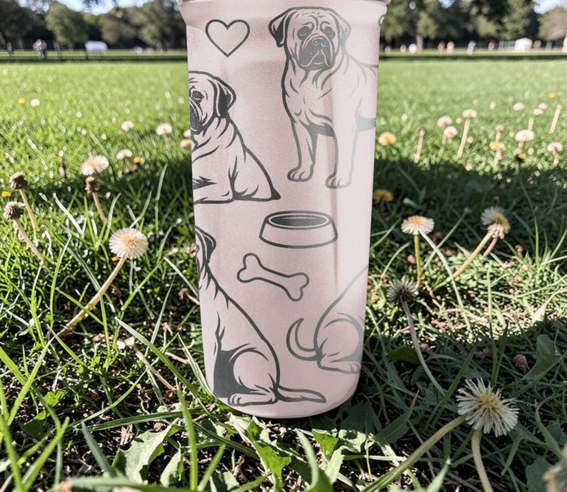 May include: A light pink tumbler featuring a repeating pattern of dog illustrations, a heart, a dog bowl, and a bone. The tumbler is cylindrical and appears to be made of a durable material. The dog illustrations are in a simple, line-art style.