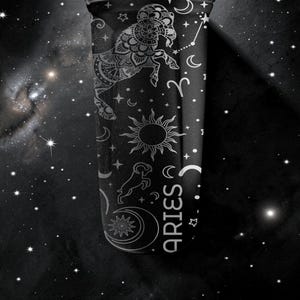 Pode incluir: Caneca preta com um design branco do zod&iacute;aco de &Aacute;ries. O design inclui um carneiro de &Aacute;ries, sol, lua, estrelas e a palavra "ARIES". O fundo &eacute; um c&eacute;u noturno escuro e estrelado.