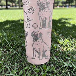 May include: A light pink tumbler featuring a repeating pattern of dog illustrations, paw prints, bones, and hearts. The dogs are depicted in a seated position. The tumbler is cylindrical and appears to be made of a durable material.