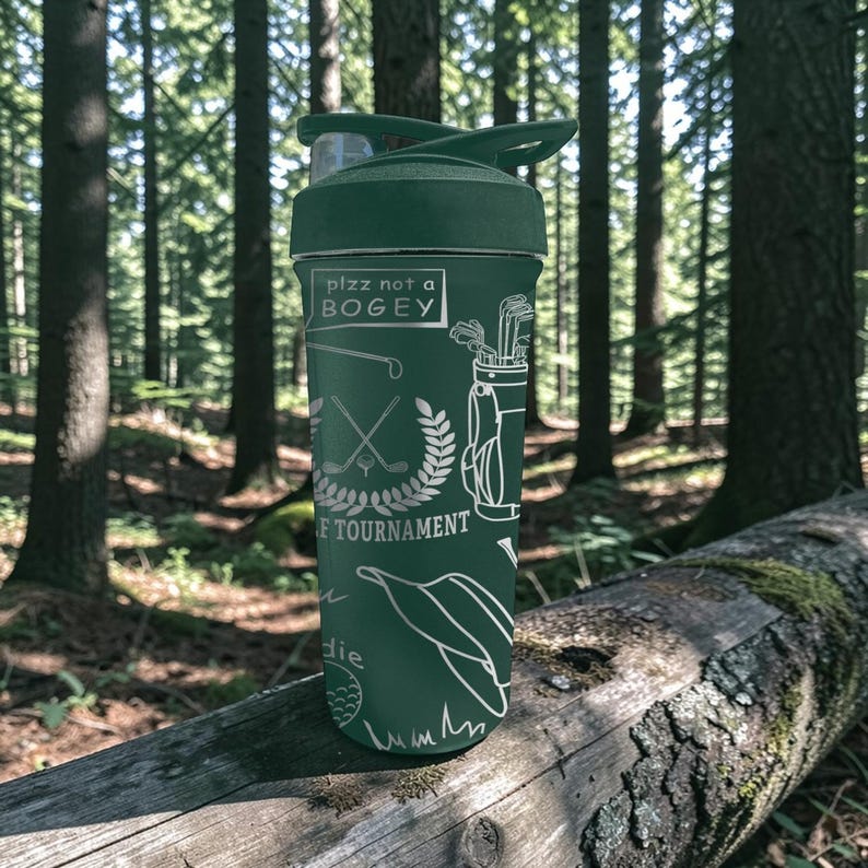 May include: A green water bottle with a black lid and a white graphic design. The design includes golf-related illustrations and the text "plzz not a BOGEY". The bottle is cylindrical and appears to be made of metal.