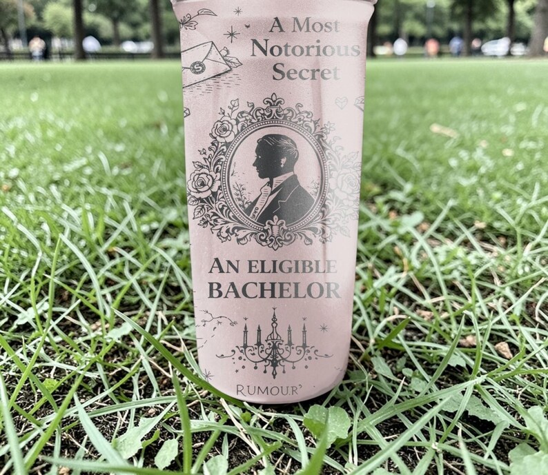 Pode incluir: Uma vela rosa com o texto "A Most Notorious Secret" e "An Eligible Bachelor". A vela apresenta uma silhueta de um homem numa moldura decorativa. A palavra "Rumour" est&aacute; impressa na parte inferior da vela.