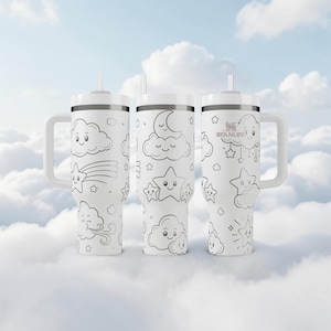 Puede incluir: Tres vasos Stanley blancos con asas y pajitas, con un patrón repetitivo de líneas negras de nubes sonrientes, estrellas, una luna creciente y una estrella fugaz que cubre el exterior de cada vaso cilíndrico de metal.