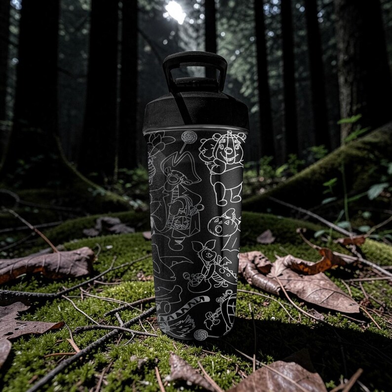 May include: Black water bottle with white cartoon character illustrations. The bottle has a black handle and lid. The background is a forest scene with moss and fallen leaves.