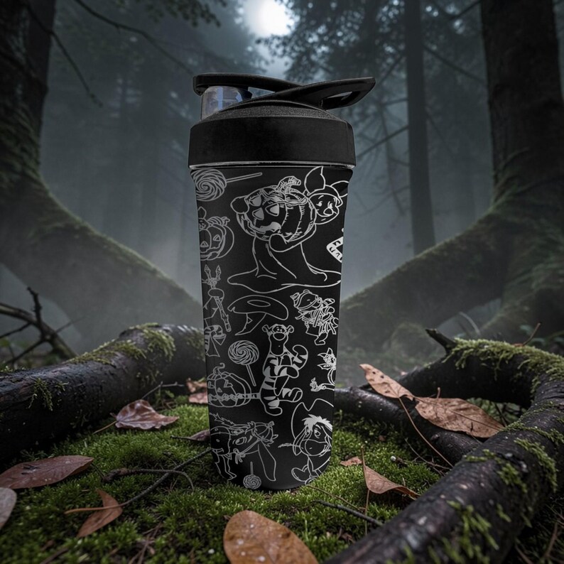 May include: Black water bottle with a black lid, decorated with white line art of cartoon characters and Halloween-themed illustrations. The bottle is cylindrical and made of plastic. The background is a forest scene with moss and fallen leaves.