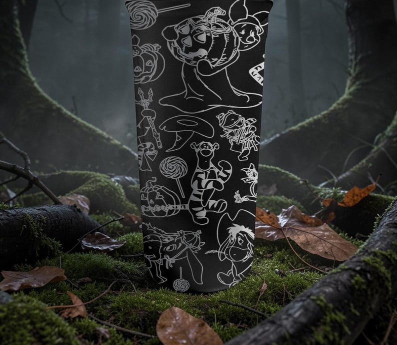 May include: Black tumbler with white line drawings of Halloween characters and items. The design includes pumpkins, lollipops, and cartoon figures. The tumbler is cylindrical.