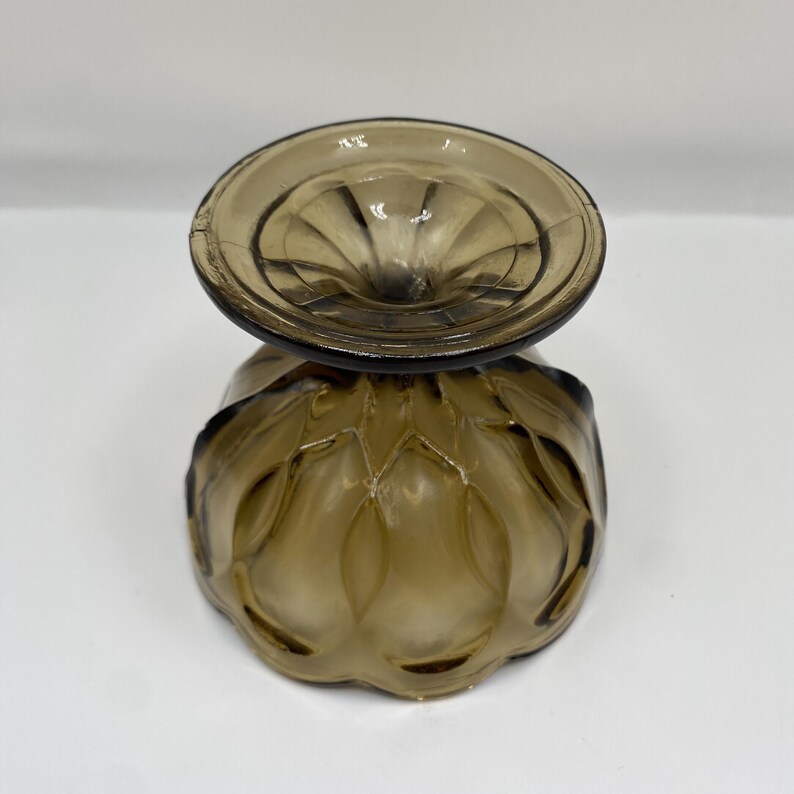 May include: An amber-coloured vintage glass dessert dish. The bowl has a textured, patterned design with a scalloped edge. The stem is short and the base is round. The glass has a slight iridescence.