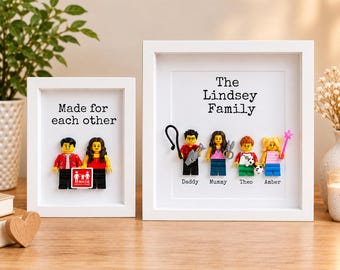 May include: Two white framed displays featuring custom minifigures. The smaller frame reads Made for each other with two figures. The larger frame reads The Lindsey Family with four figures labeled Daddy, Mummy, Theo, and Amber, each holding accessories.
