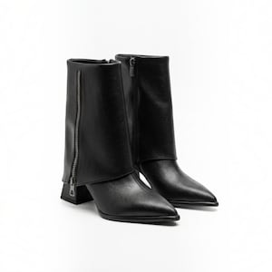 May include: A pair of black ankle boots featuring a pointed toe, a block heel, and a distinctive fold-over cuff design. Each boot is accented with a vertical silver-toned metal zip running along the outer side of the shaft for closure.