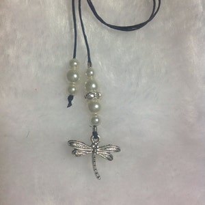 May include: A black bookmark with white pearl beads and a silver dragonfly charm.