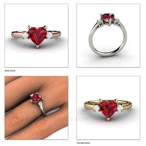 May include: A heart-shaped ruby engagement ring with two smaller diamonds on either side of the center stone. The ring is shown in both rose gold and yellow gold.