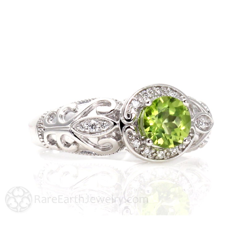 Art deco style peridot and diamond ring natural green gemstone ring with diamonds filigree scrolls and vines vintage inspired design.