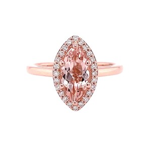 May include: A rose gold ring with a marquise-shaped morganite gemstone surrounded by a halo of smaller diamonds.