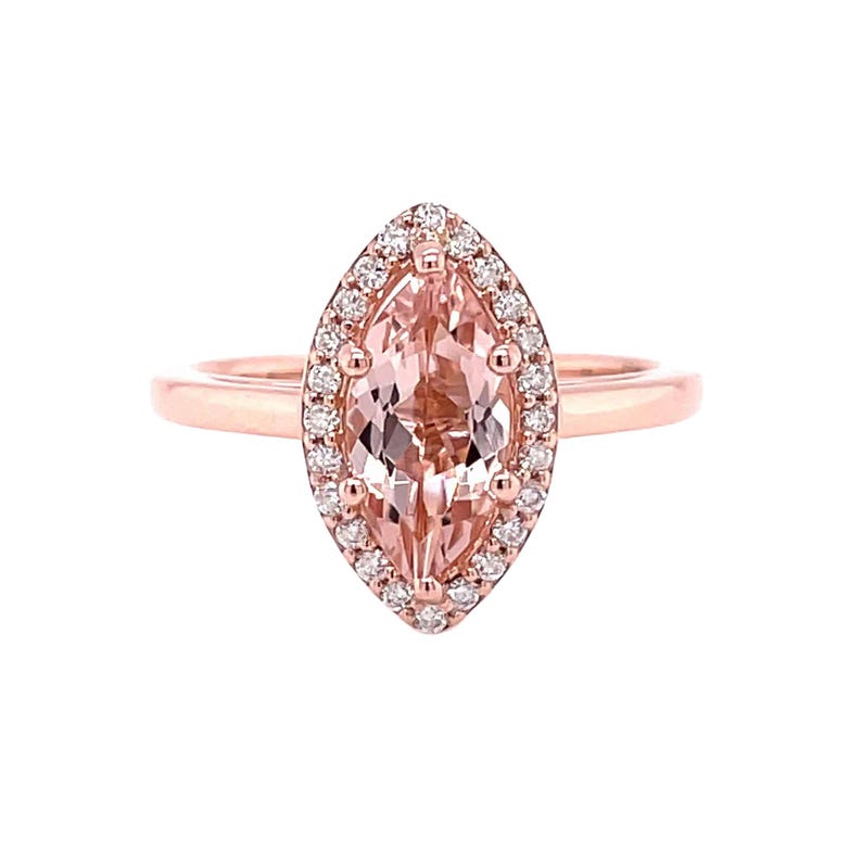 May include: A rose gold ring with a marquise-shaped morganite gemstone surrounded by a halo of smaller diamonds.