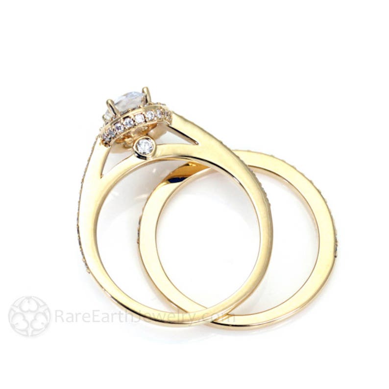 May include: A gold wedding band set with a center stone and a halo of smaller stones. The band is set with smaller stones around the entire band.