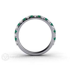 K&ouml;nnte beinhalten: Ein silberner Bandring mit abwechselnd Smaragden und Diamanten. Der Ring hat eine durchgehende Reihe kleiner, rund geschliffener Smaragde und Diamanten, die um das Band gesetzt sind. Die Edelsteine sind gleichm&auml;&szlig;ig verteilt und erzeugen ein funkelndes und elegantes Design.