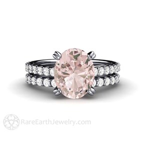Op de afbeelding: Een delicate verlovingsring met een grote ovale roze morganiet-edelsteen omgeven door een halo van kleinere diamanten. De ring is gezet op een dunne band met een bijpassende band bezet met diamanten.