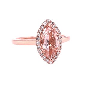 May include: A rose gold ring with a marquise-shaped morganite gemstone surrounded by a halo of smaller diamonds.