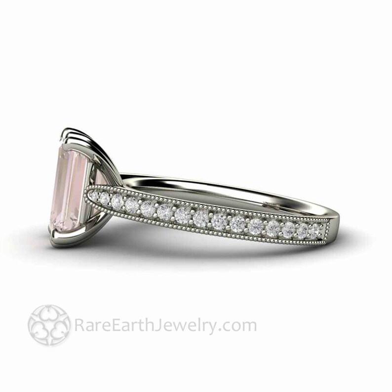 May include: A delicate engagement ring with a pale pink emerald-cut gemstone surrounded by a band of small diamonds.