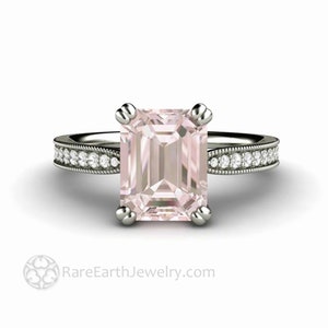 May include: A silver engagement ring with a pink emerald-cut gemstone and a diamond-encrusted band. RareEarthJewelry.com